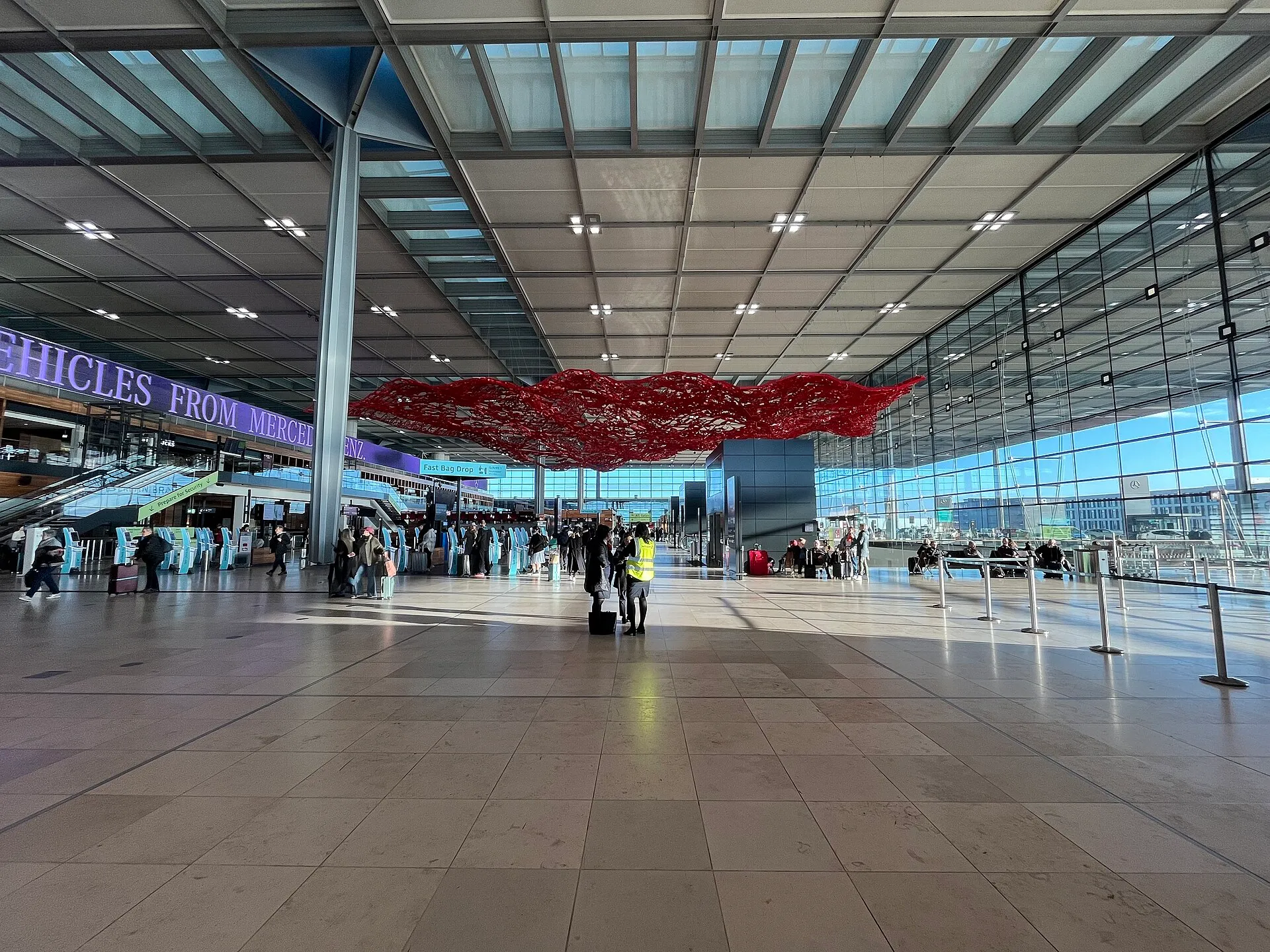 Le hall principal du terminal 1 de l'aéroport de Berlin-Brandebourg (BER), dominé par une grande sculpture rouge suspendue sous la verrière