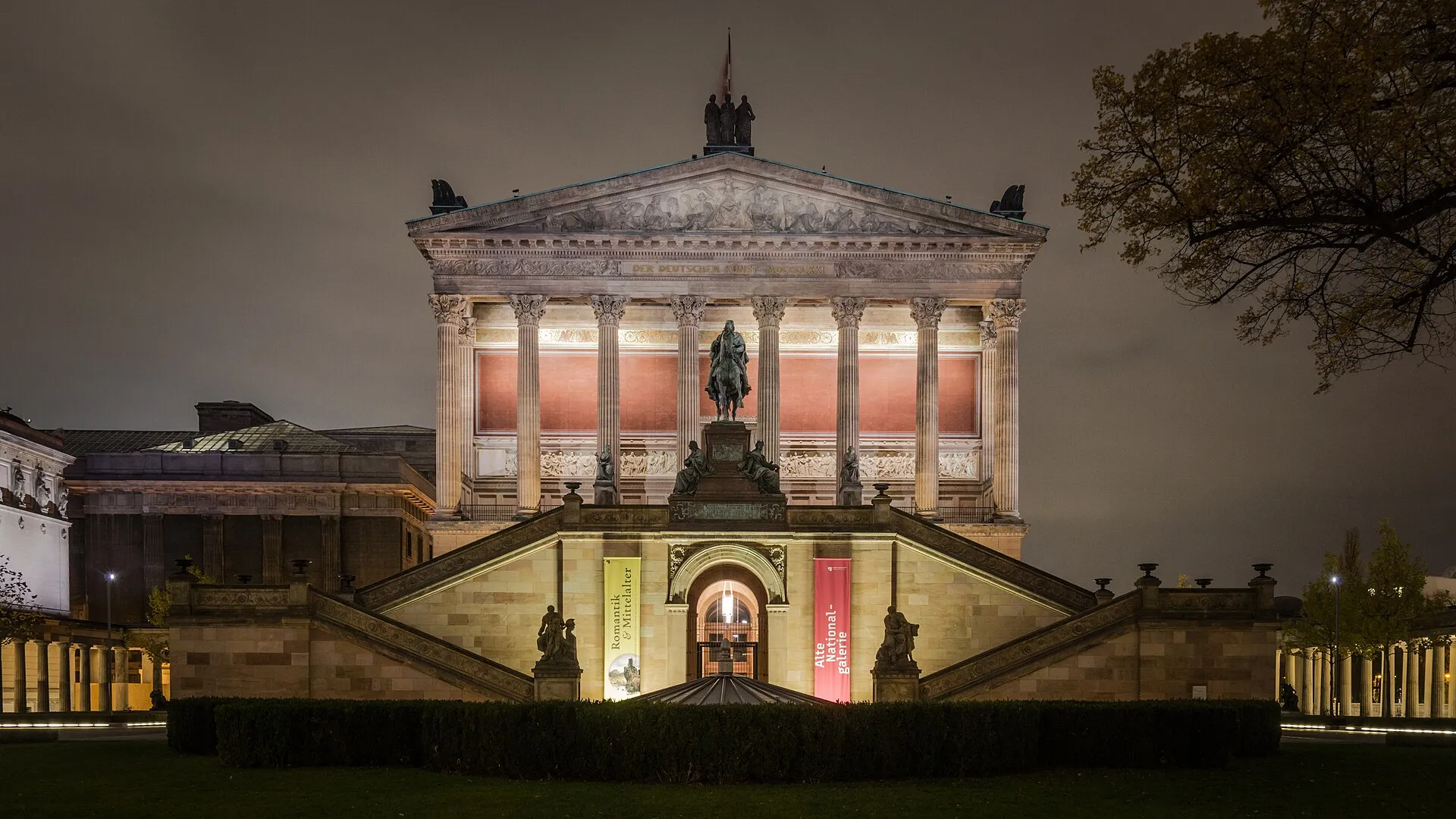 L'Alte Nationalgalerie illuminée de nuit sur l'île aux musées, avec sa statue équestre devant l'escalier du portique