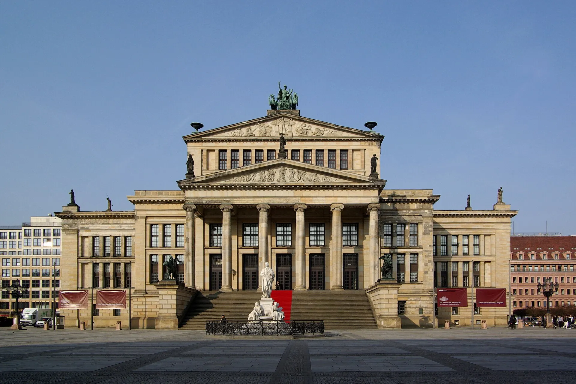 La façade néoclassique du Konzerthaus sur la Gendarmenmarkt, avec son portique à colonnes corinthiennes et la statue de Schiller au premier plan