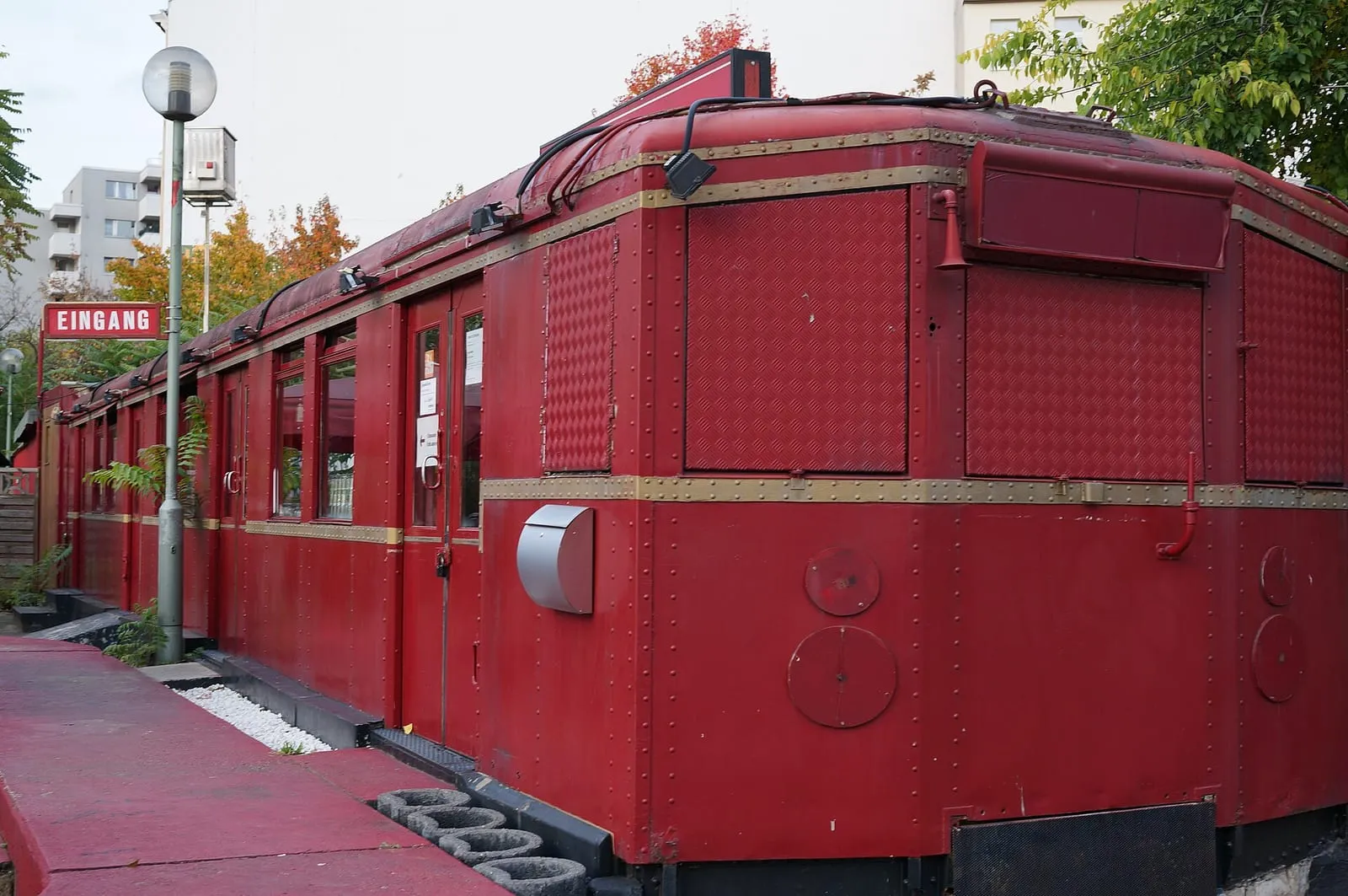 Le wagon rouge du Train Cocktailbar à Schöneberg, avec son entrée signalée par un panneau EINGANG