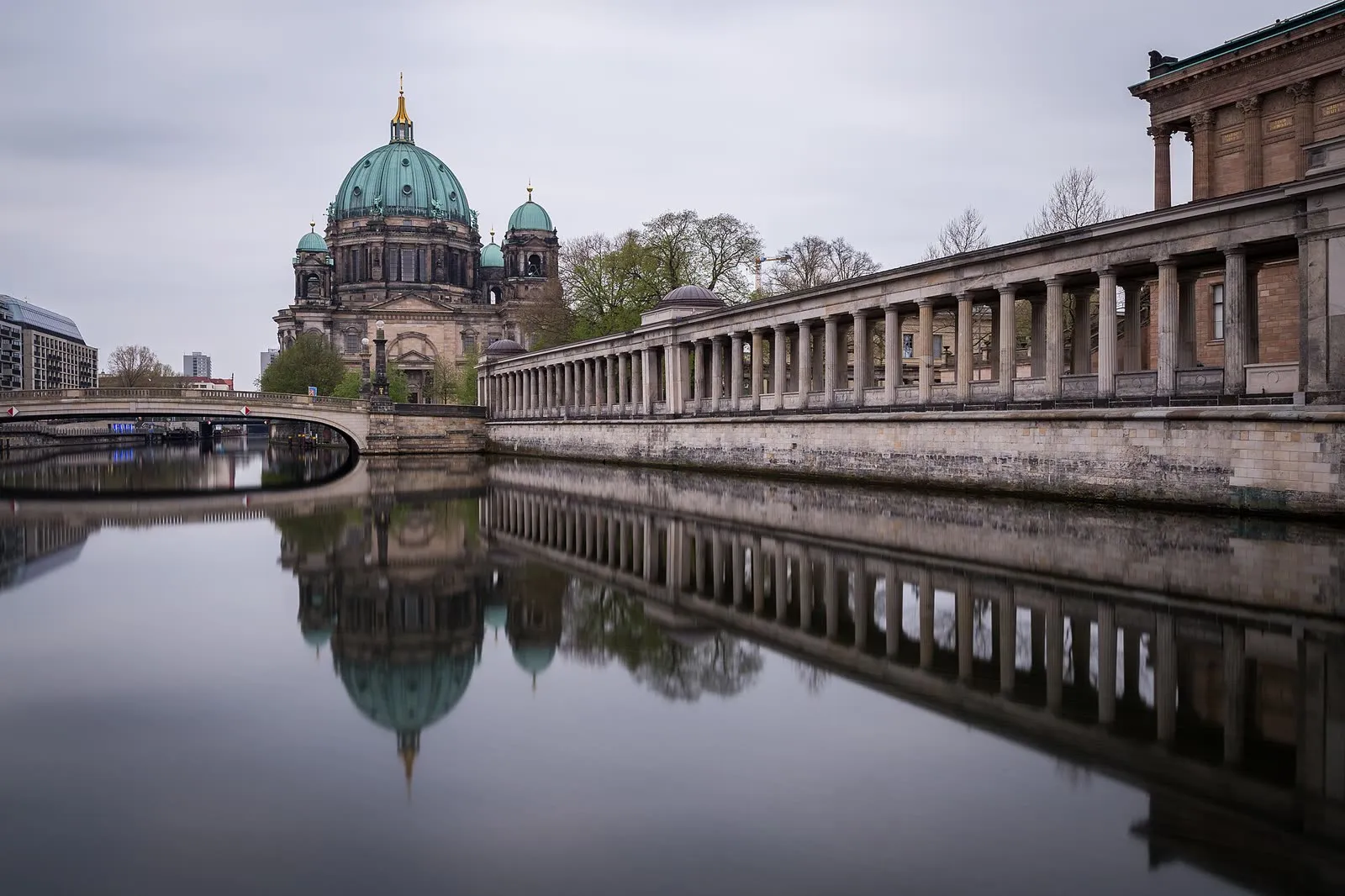 La cathédrale de Berlin et sa coupole de cuivre vert se reflétant dans la Spree, avec la colonnade de l'île aux Musées sur la droite