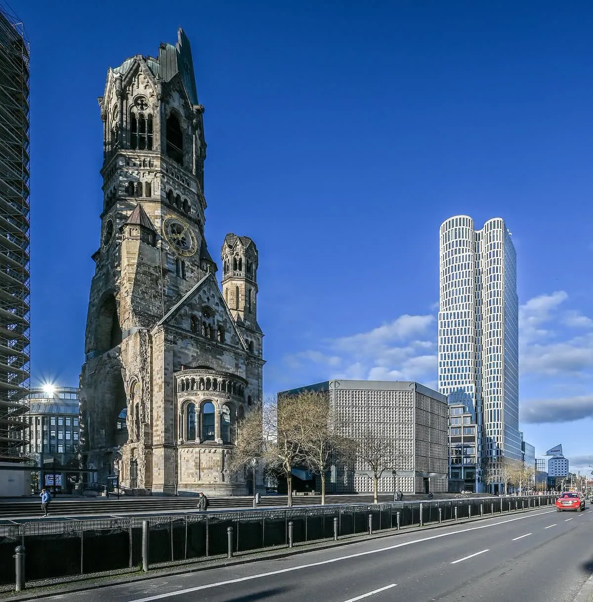 La tour en ruine de l'église du Souvenir sur le Breitscheidplatz, avec la place et la tour du Zoofenster derrière