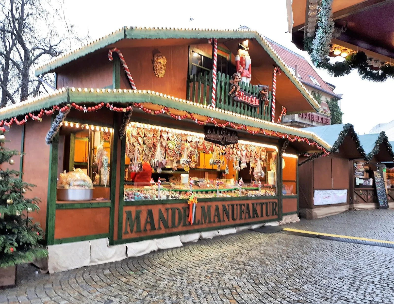 Un stand d'amandes caramélisées au marché de Noël de Spandau, avec ses guirlandes lumineuses et ses décorations de Noël sur les pavés