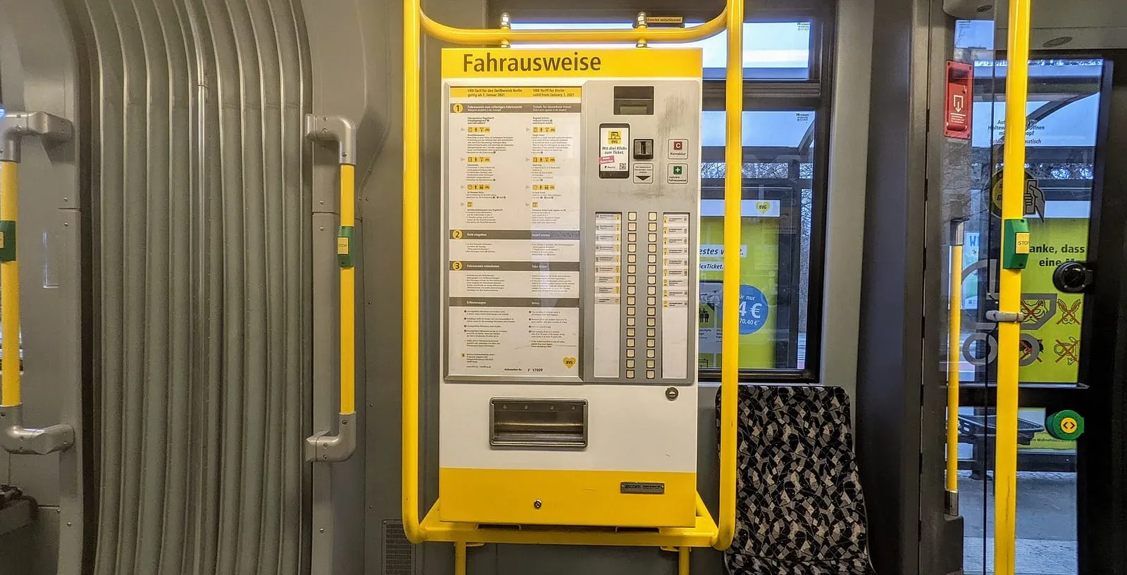 Distributeur automatique de billets de la BVG à l'intérieur d'un tramway berlinois, avec la grille des tarifs affichée sur la machine