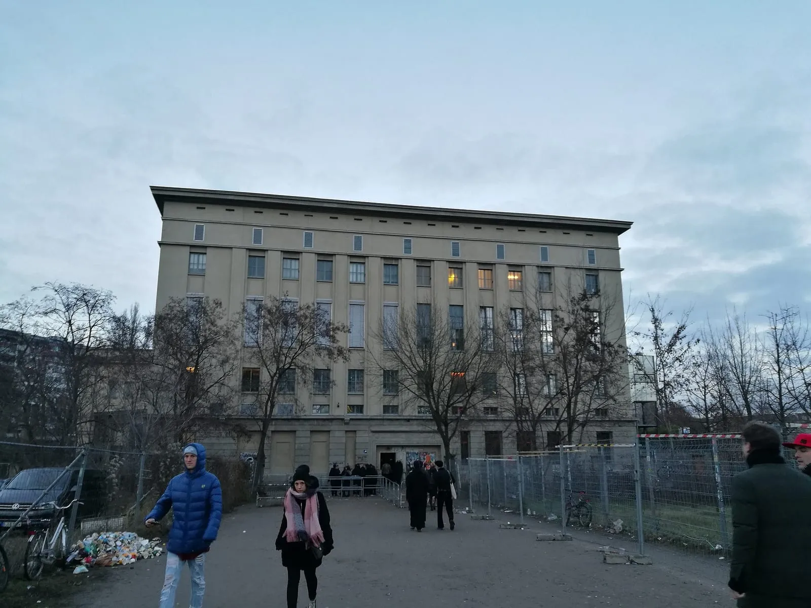 L'entrée du Berghain à Berlin, avec sa longue façade industrielle et la file d'attente derrière les barrières