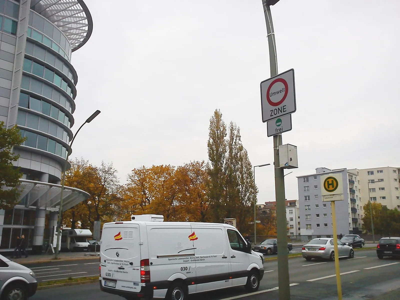 Le panneau rond « Umwelt ZONE » bordé de rouge, complété d'un panneau « frei », au bord d'une avenue berlinoise devant un immeuble de bureaux