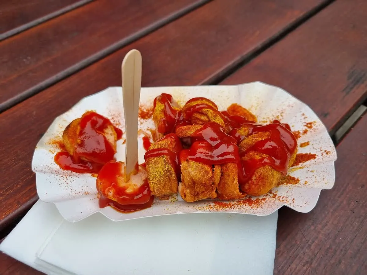 Une currywurst berlinoise coupée en rondelles, nappée de sauce tomate au curry et saupoudrée de poudre de curry