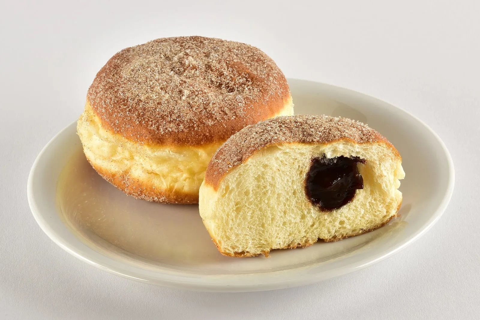 Deux Berliner Pfannkuchen, beignets fourrés à la confiture, coupés pour montrer la garniture