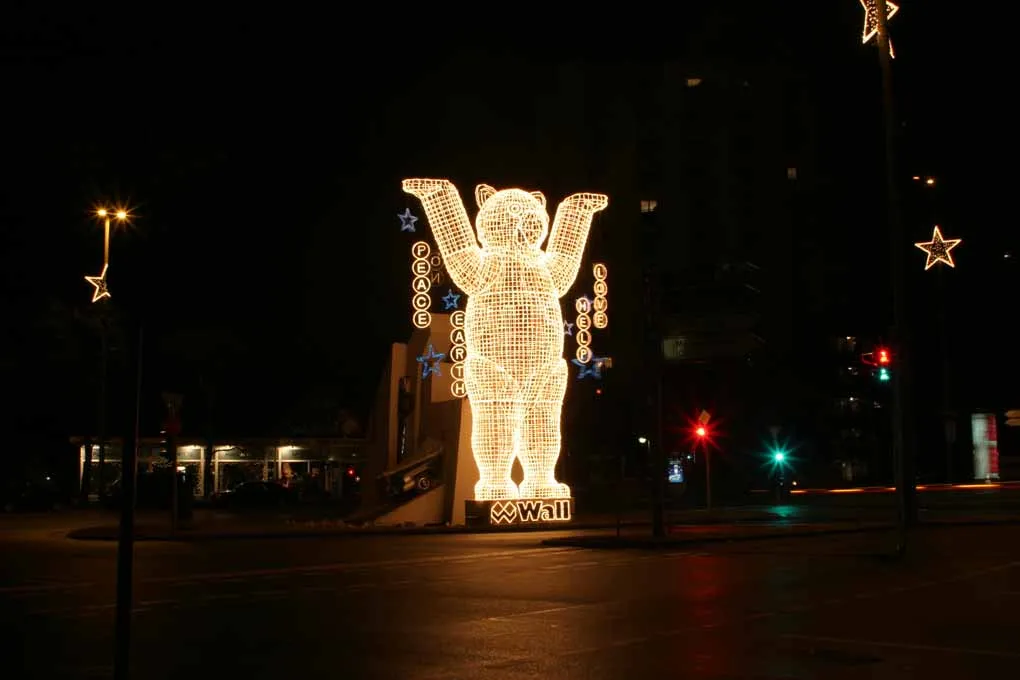 Rue berlinoise décorée pour Noël, grandes étoiles lumineuses suspendues aux réverbères et ours lumineux portant les mots Peace, Earth, Love et Help