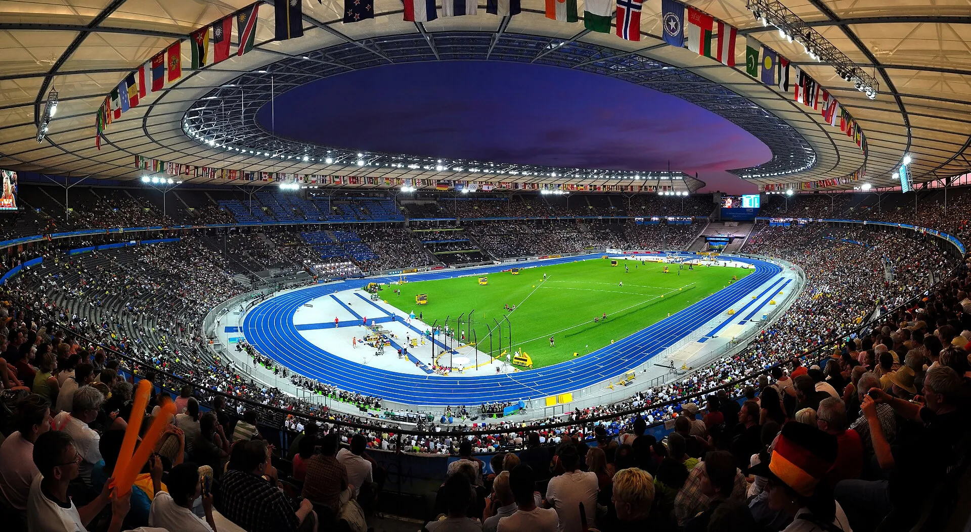 Vue de l'intérieur de l'Olympiastadion de Berlin, tribunes pleines en soirée