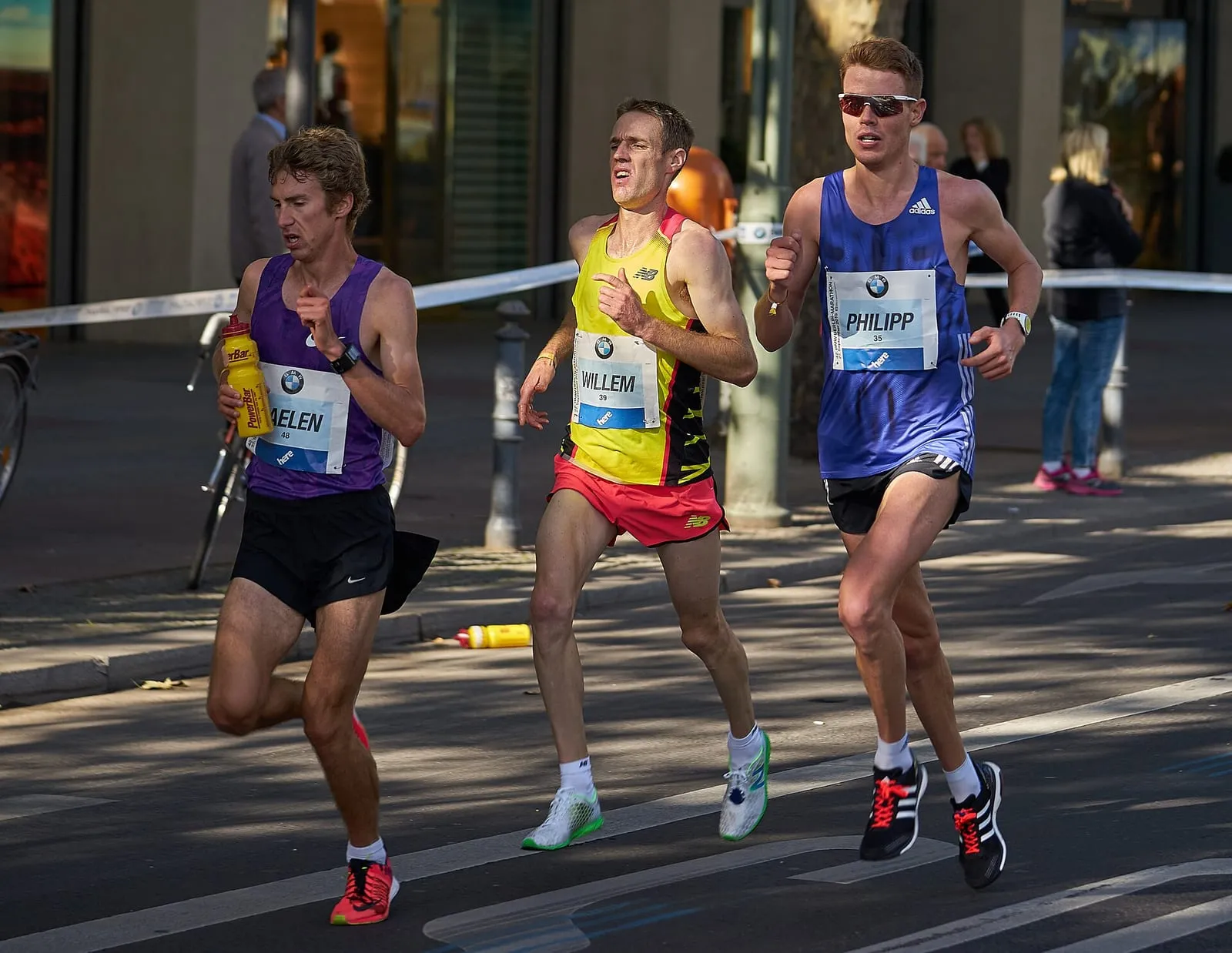Coureurs du marathon dans une rue de Berlin, dossards de course bien visibles