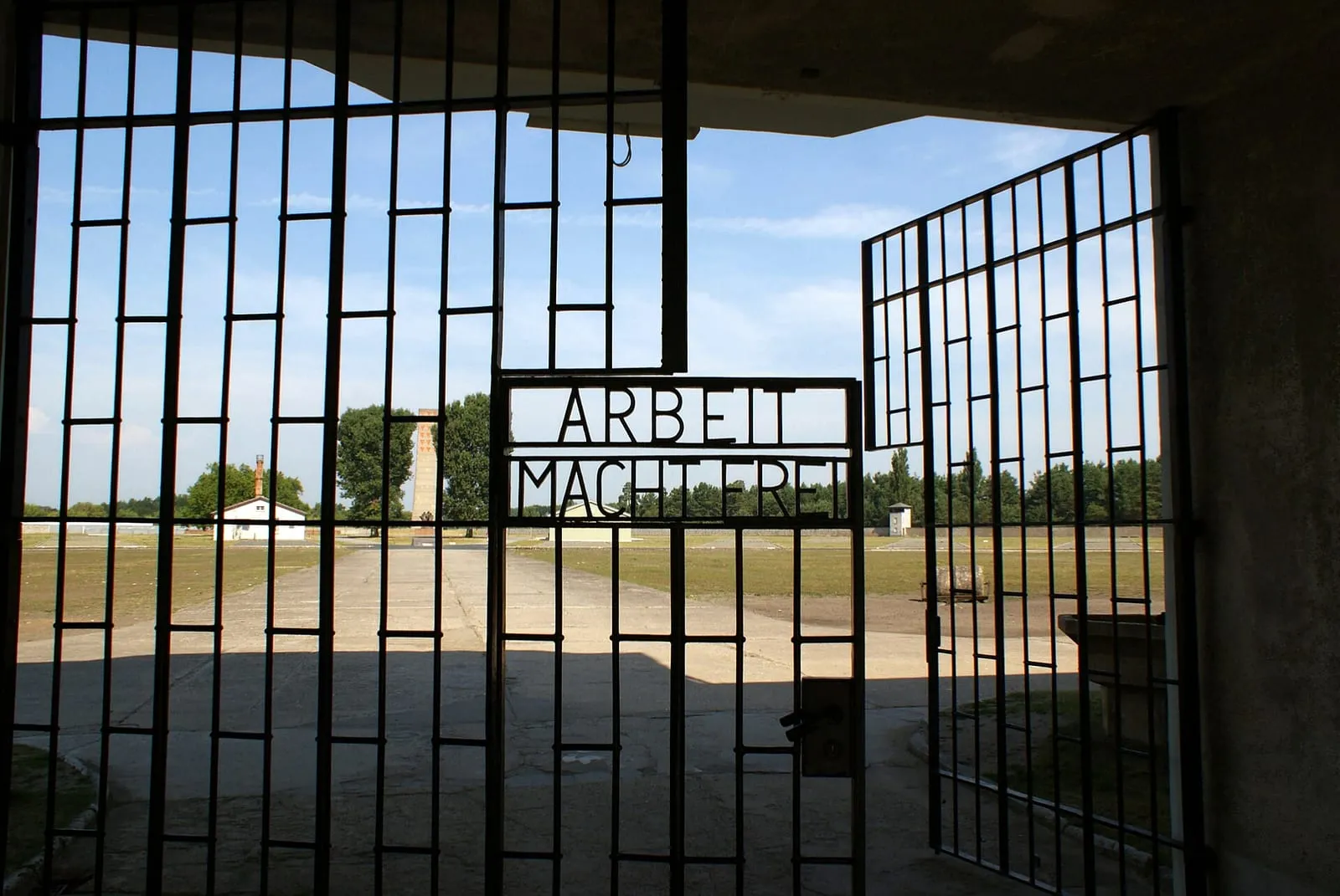 La grille de la tour A vue depuis l'intérieur du camp, avec l'inscription Arbeit macht frei en lettres de fer