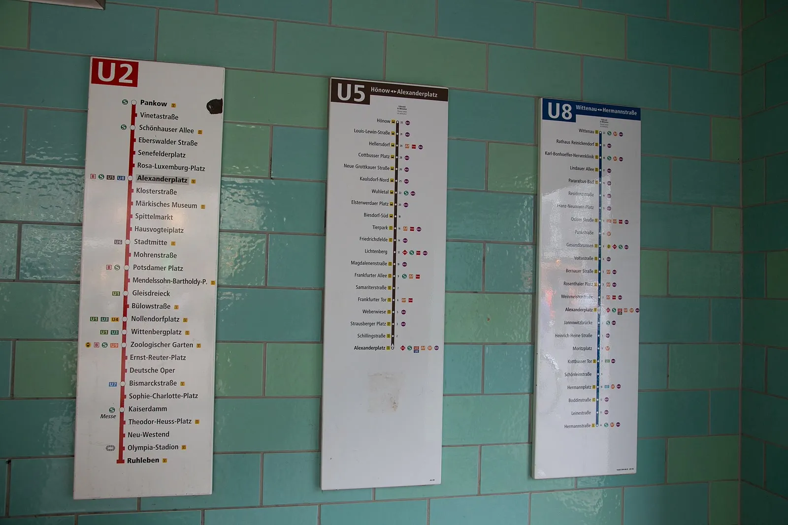 Plans des lignes U2, U5 et U8 affichés sur le mur carrelé d'un quai de la station Alexanderplatz