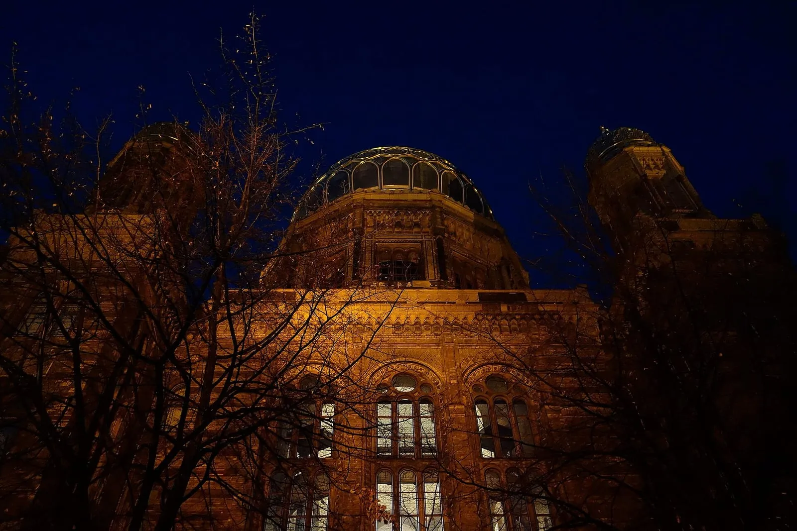 La Nouvelle Synagogue de Berlin illuminée en soirée, son dôme doré dominant l'Oranienburger Straße