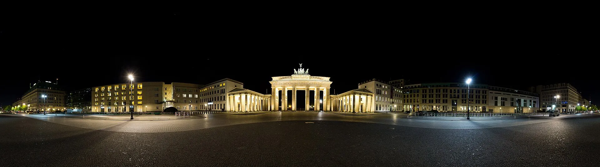Panorama nocturne de la porte de Brandebourg et de ses deux maisons de garde, sur le Pariser Platz