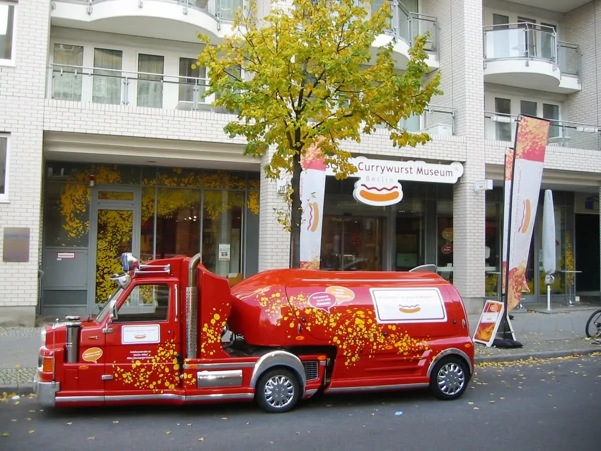 L'entrée du Deutsches Currywurst Museum à la Schützenstraße 70, à Berlin-Mitte, avec son enseigne et une remorque publicitaire rouge