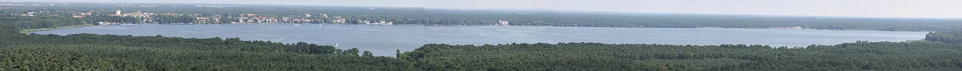 Panorama estival du Müggelsee, le plus grand lac de Berlin, avec voiliers et rives boisées à l'horizon