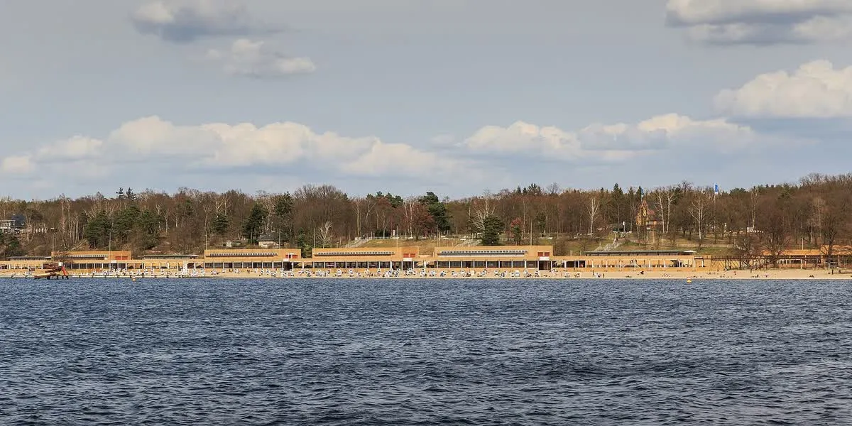 Le Strandbad Wannsee vu depuis le lac, sa longue plage de sable et ses chaises longues devant les bâtiments du lido historique