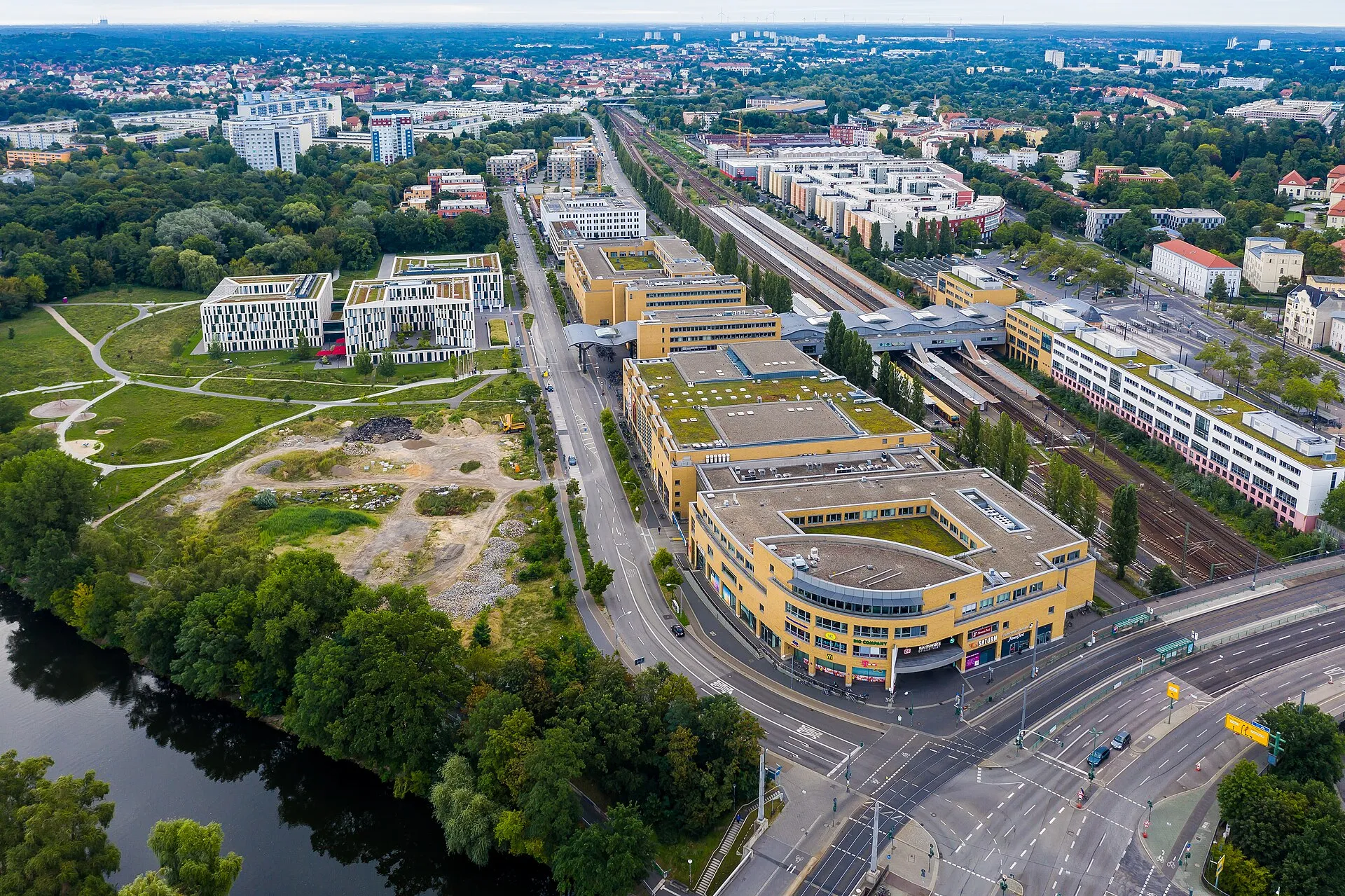 Vue aérienne de la gare centrale de Potsdam, de son bâtiment jaune arrondi et des voies ferrées qui filent vers le nord