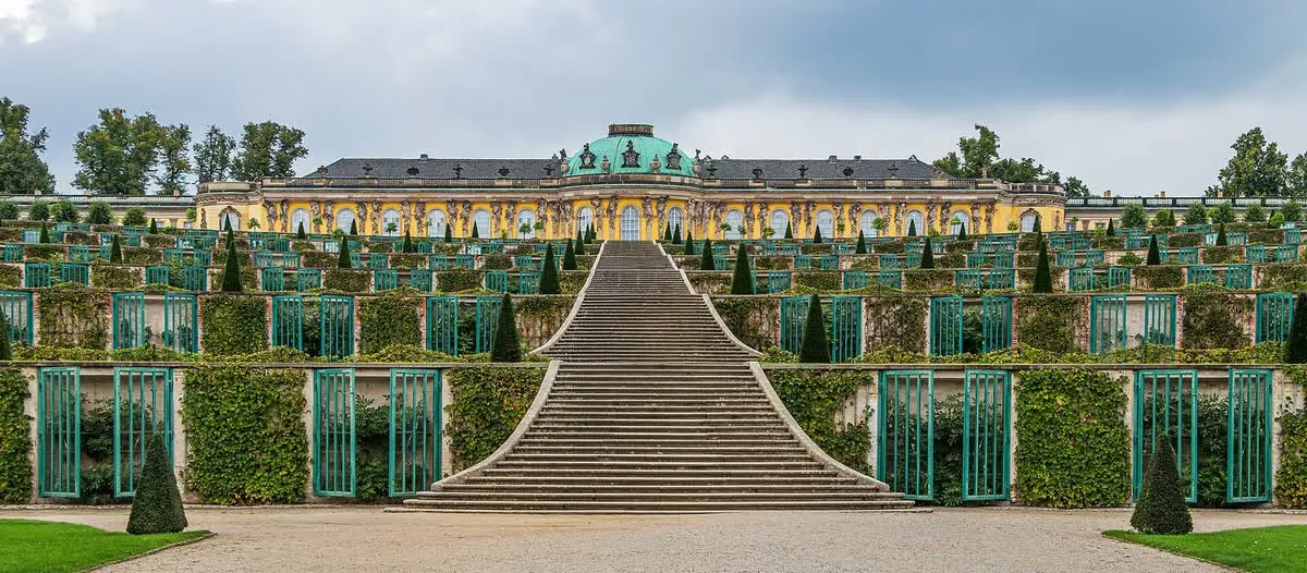 Le palais de Sanssouci et son dôme vert au sommet des terrasses de vigne, avec l'escalier central descendant vers le parc