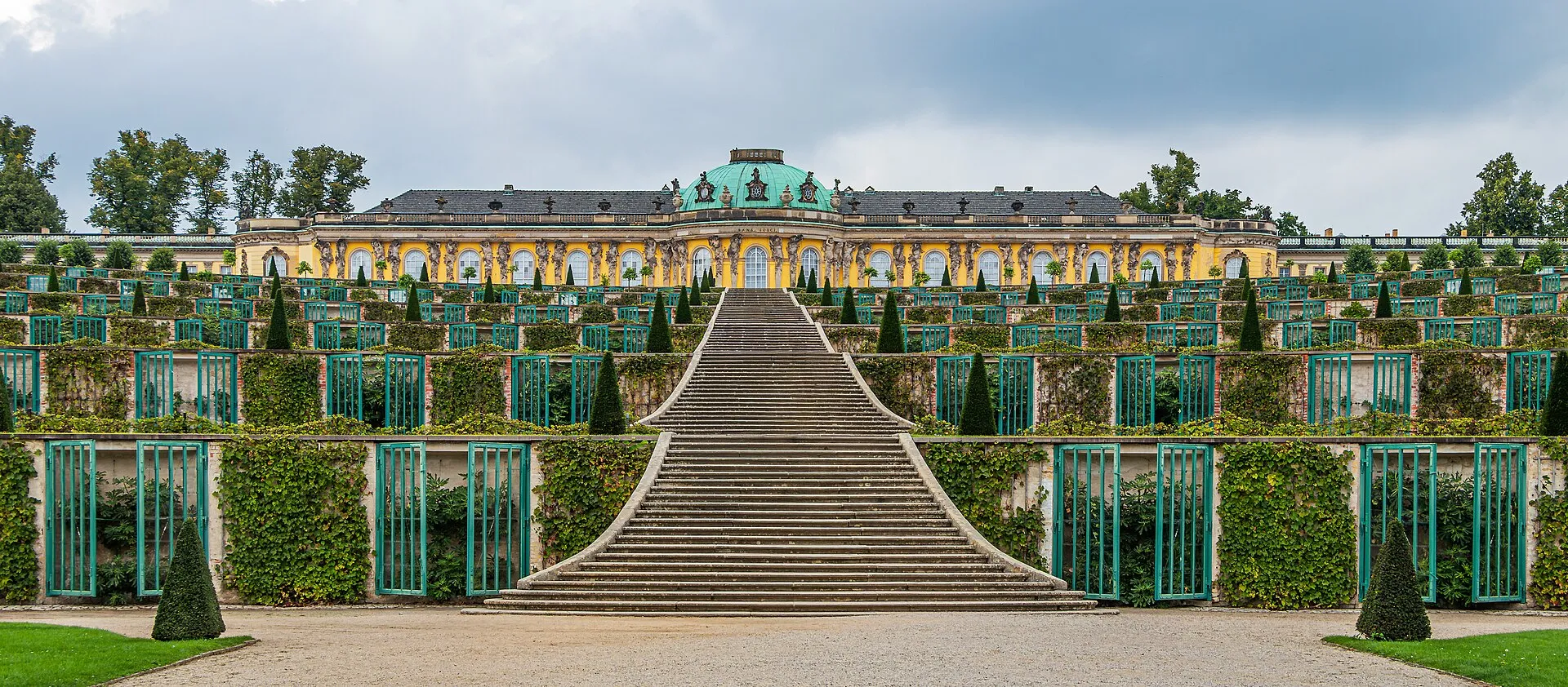 Le palais de Sanssouci et son dôme vert au sommet des terrasses de vigne, avec l'escalier central descendant vers le parc