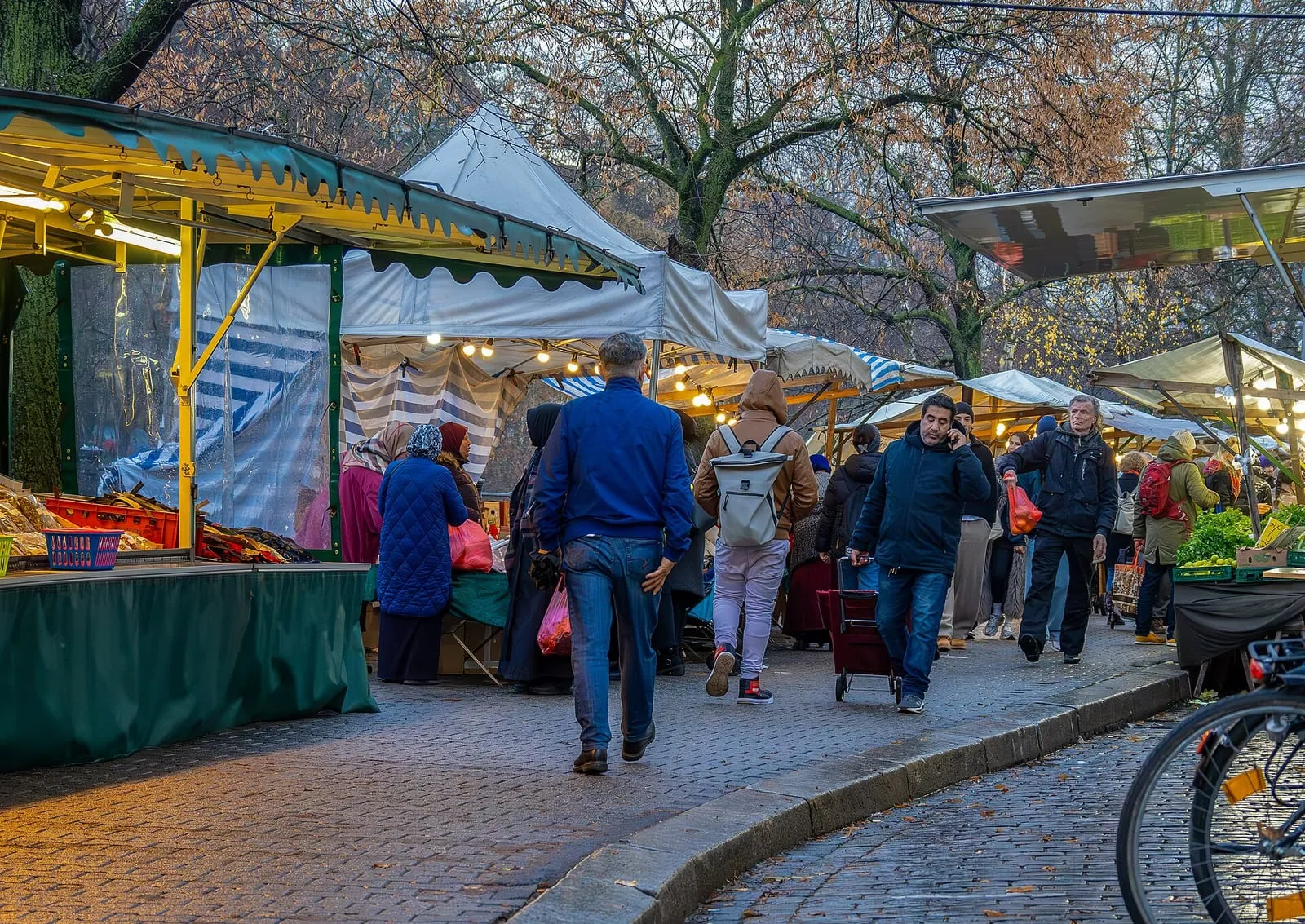Les étals du marché du Maybachufer sous leurs bâches, un jour de marché d'hiver, avec les passants sur le pavé
