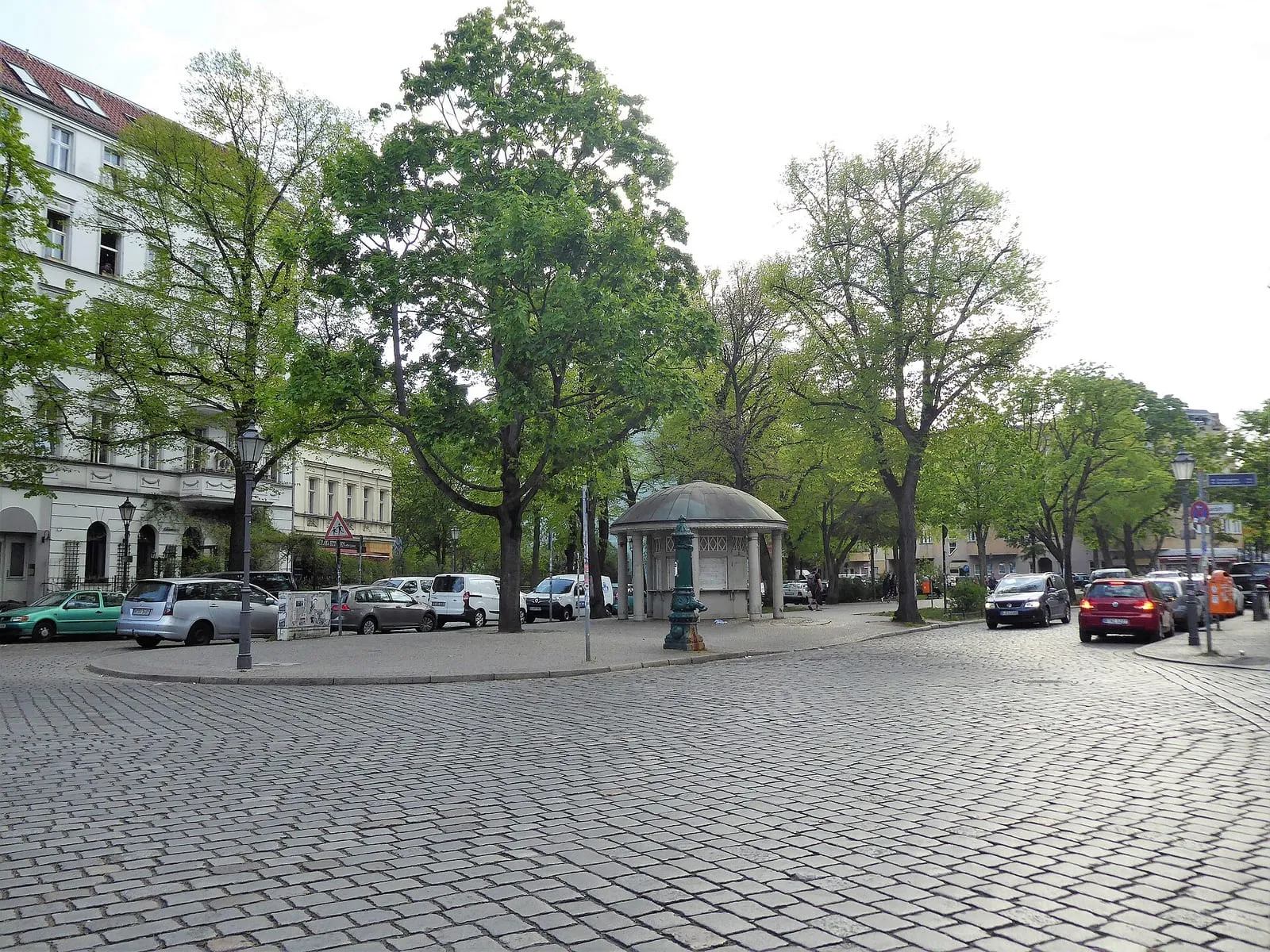 La place Richardplatz, ses grands arbres, son kiosque central et les immeubles anciens qui l'entourent