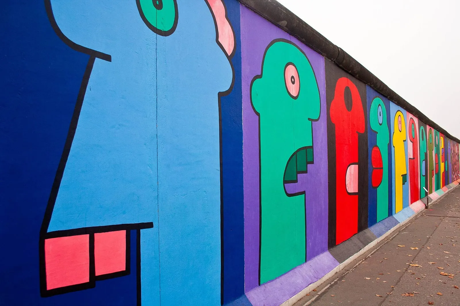 Les têtes colorées peintes par Thierry Noir sur le mur de Berlin, le long de la Mühlenstraße à Friedrichshain
