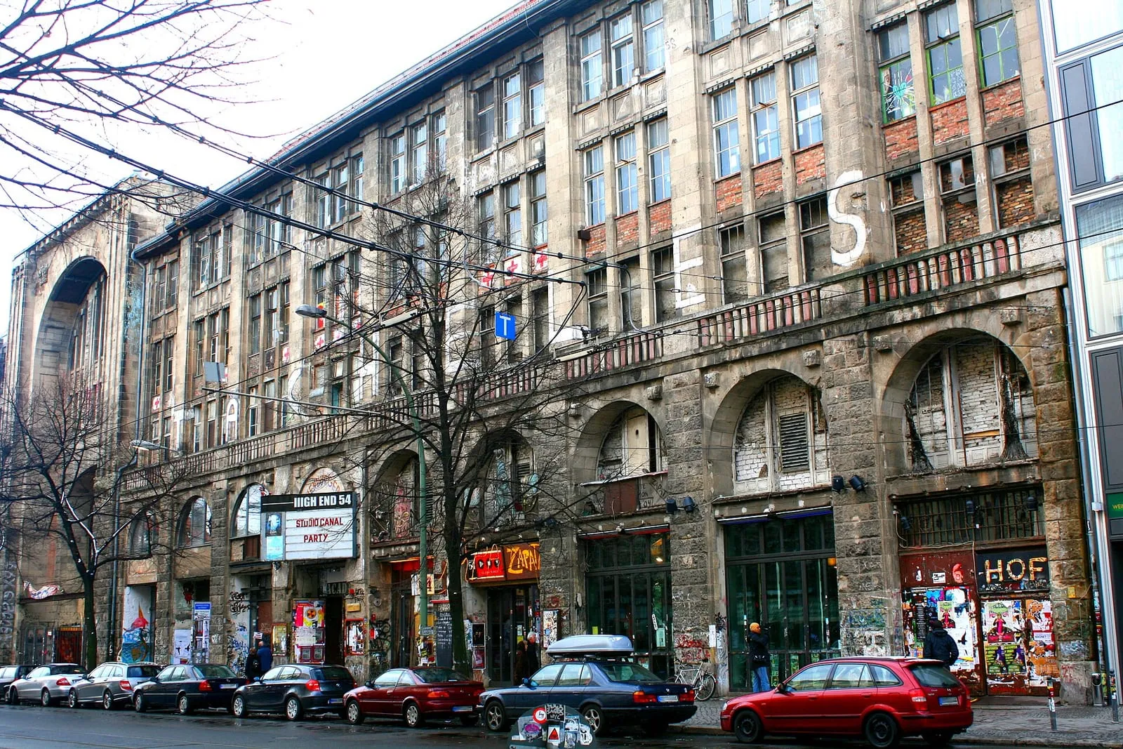 La façade du Kunsthaus Tacheles en 2008, encore occupée : tags, affiche du High End 54 et enseigne du Café Zapata au rez-de-chaussée