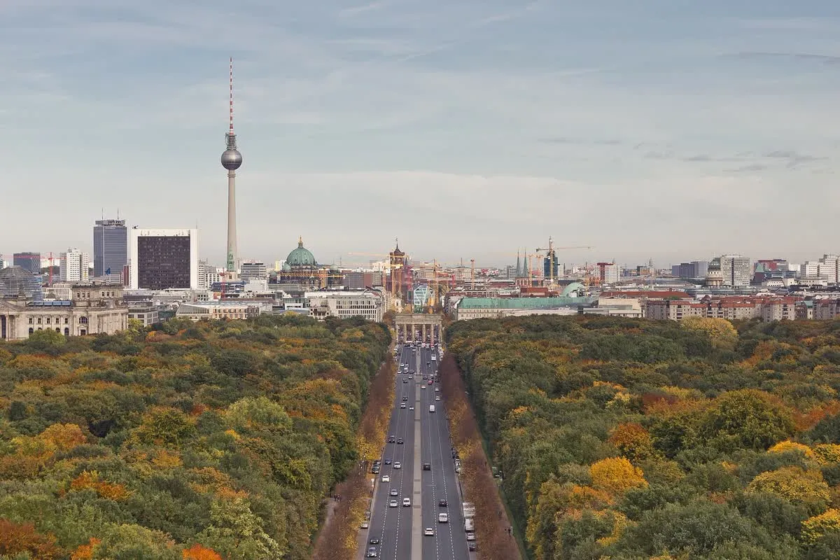 Vue depuis la colonne de la Victoire sur la Straße des 17. Juni traversant le Tiergarten, arbres d'automne et porte de Brandebourg au loin, tour de la télévision à gauche