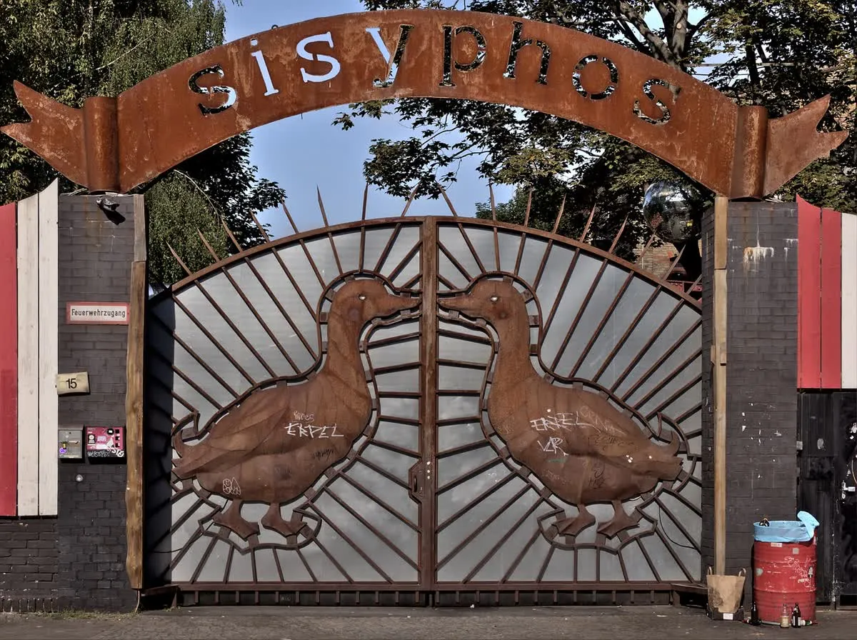 Le portail du Sisyphos à Berlin, surmonté de l’arche rouillée et gardé par deux canards de métal qui s’embrassent