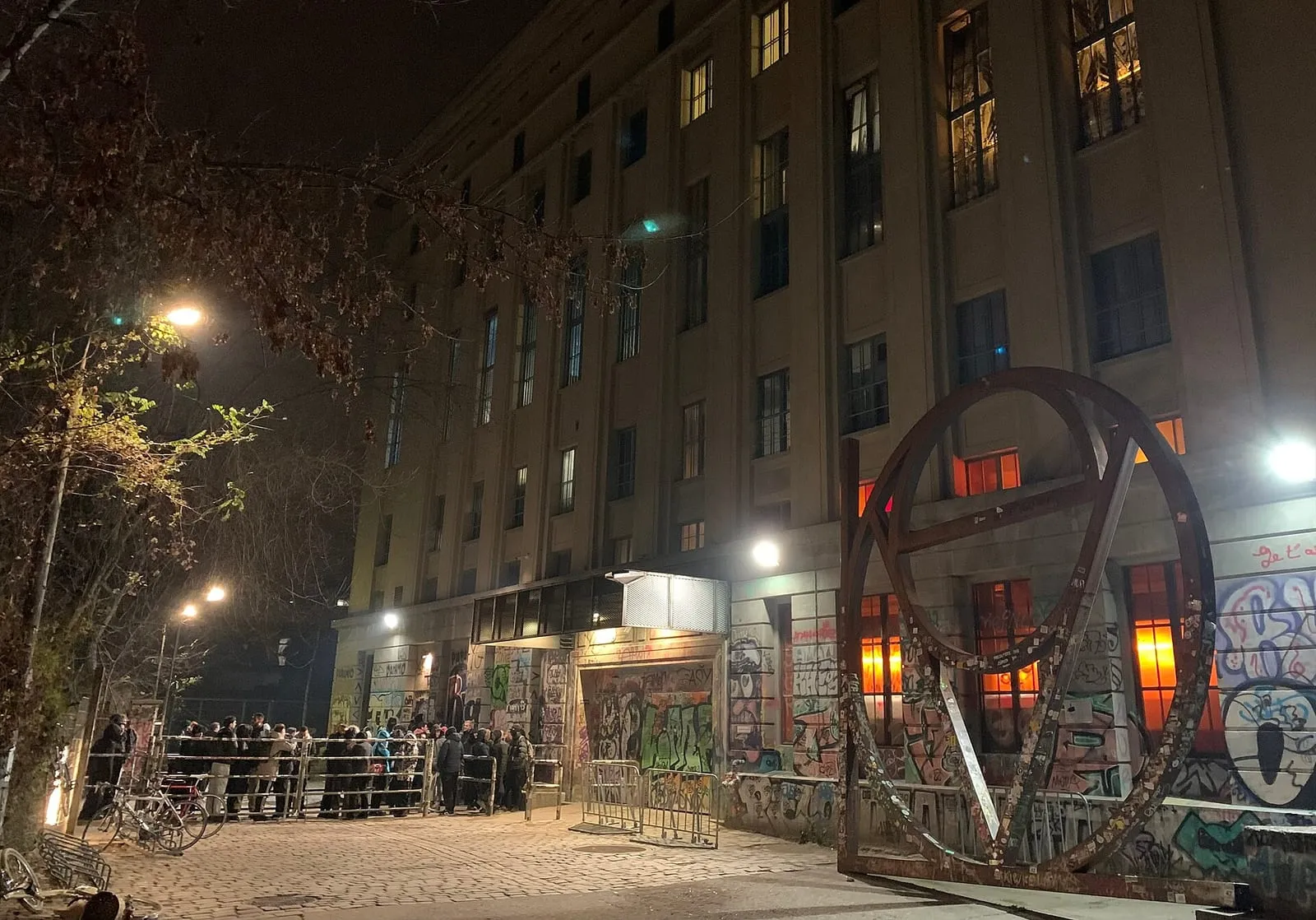 La file d'attente devant le Berghain à Berlin, le long du bâtiment industriel éclairé la nuit