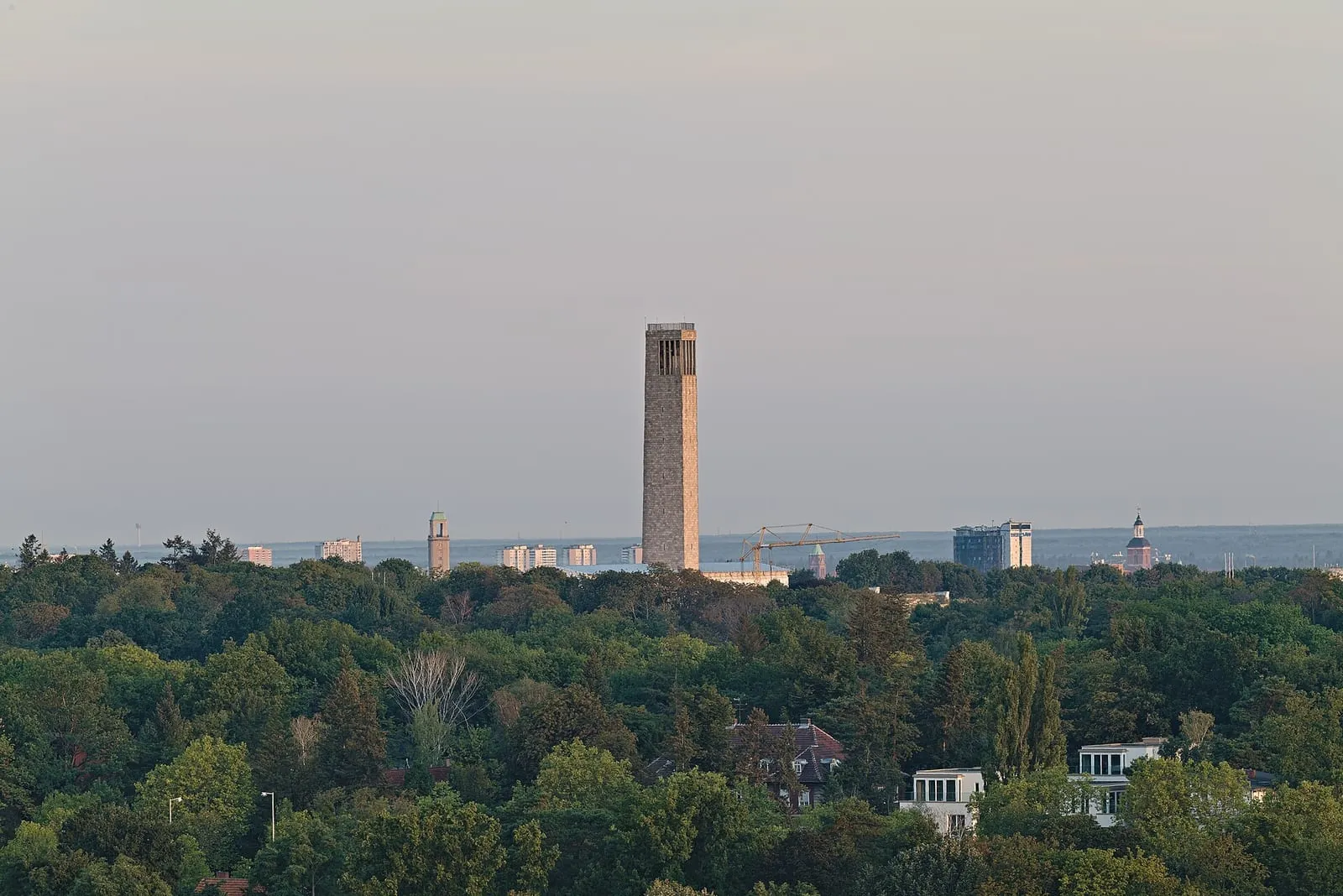 La tour de la cloche (Glockenturm) du stade olympique de Berlin vue de loin, au-dessus de la forêt