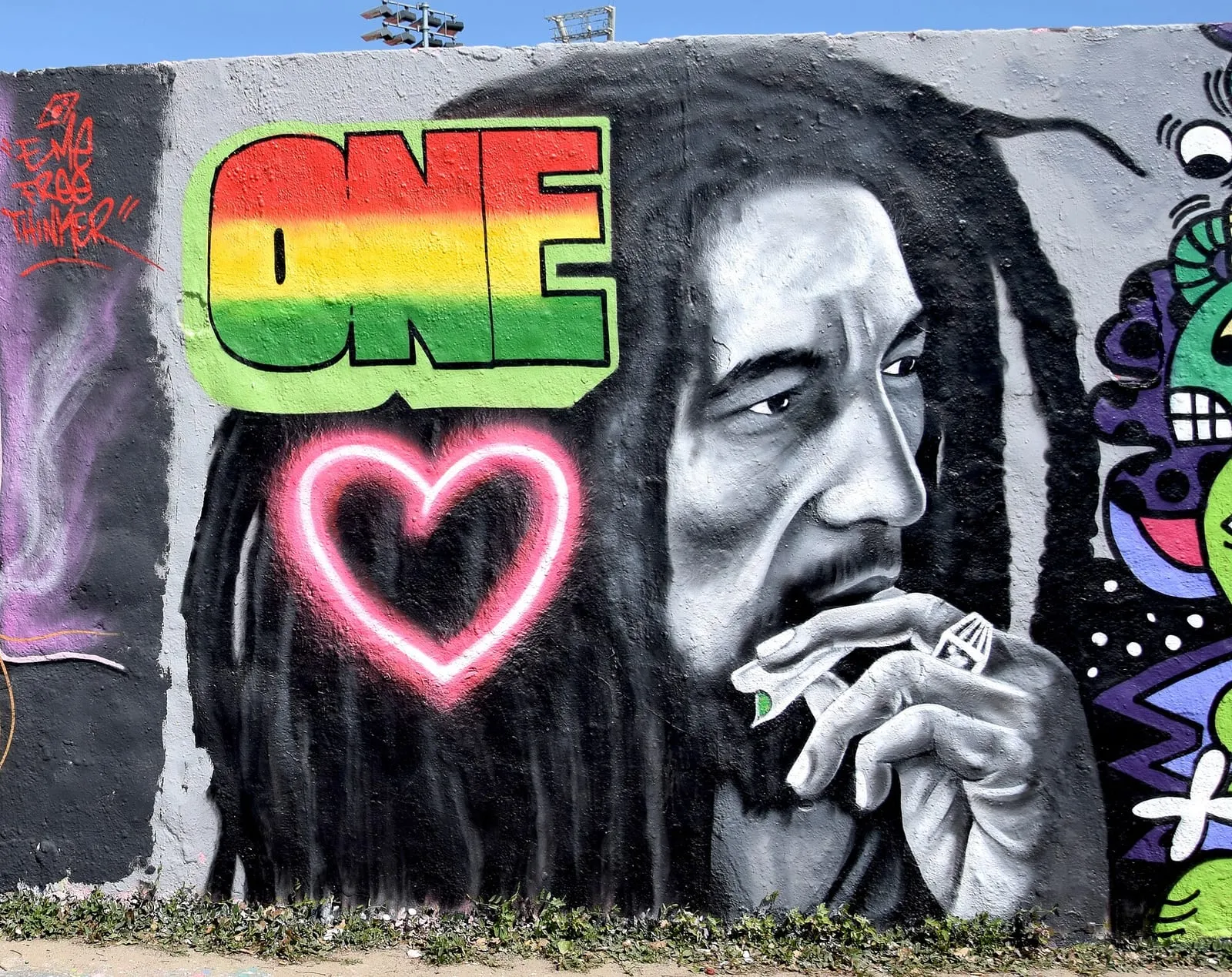 Mur peint du Mauerpark à Berlin, portrait de Bob Marley, tag et graffitis superposés sur le béton