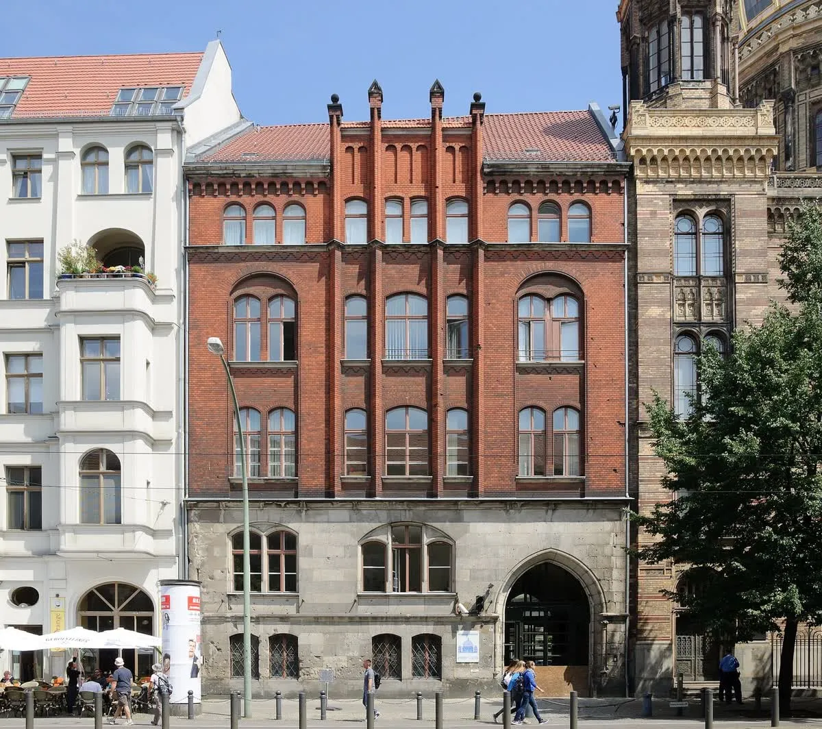 Immeuble en brique rouge de l'Oranienburger Straße, avec le dôme doré de la Neue Synagoge qui dépasse à droite