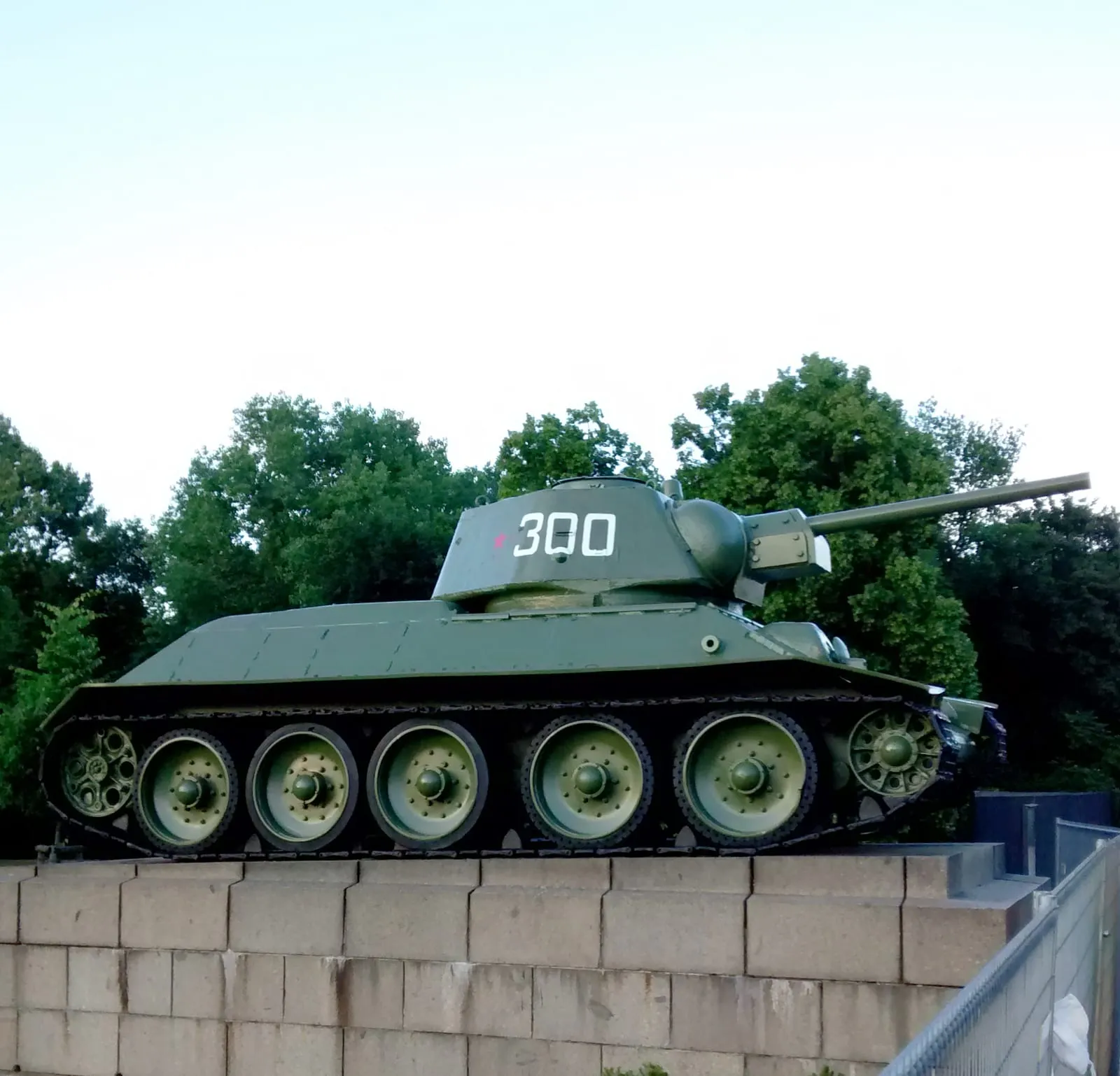Le char T-34 exposé sur son socle à l'entrée du mémorial soviétique du Tiergarten, devant les arbres du parc