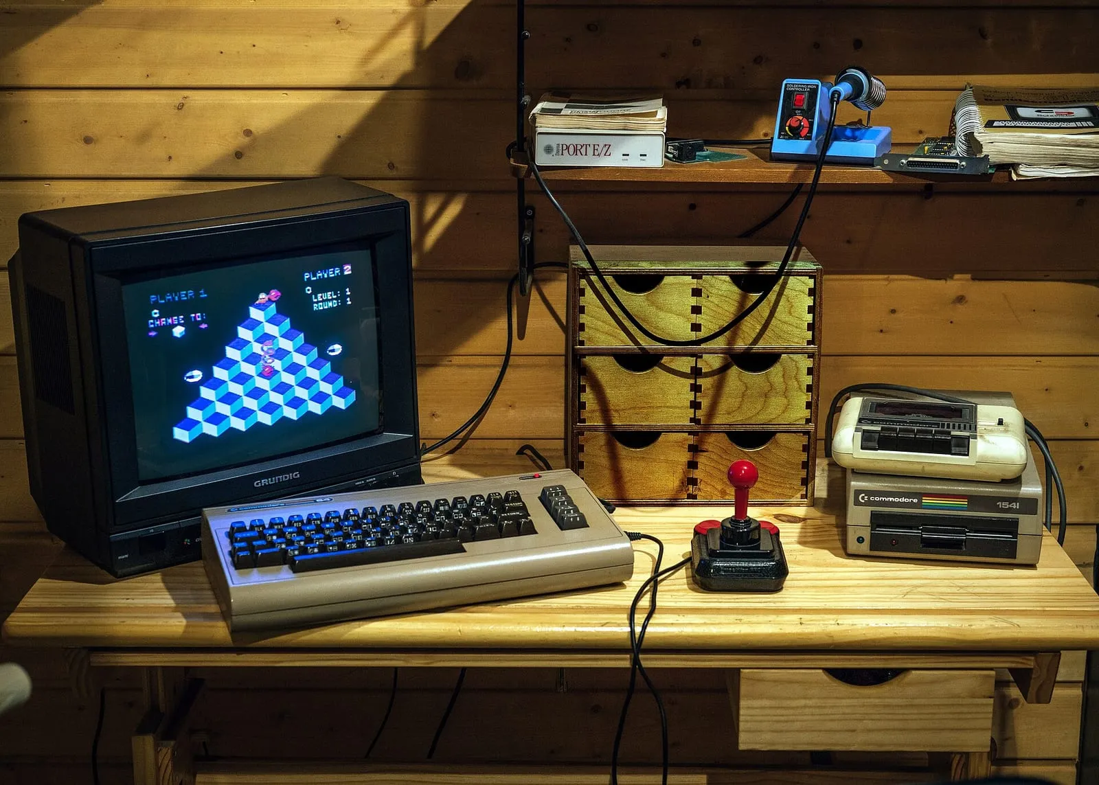Un Commodore 64 et son moniteur à tube dans une vitrine du Computerspielemuseum de Berlin, avec manette, cartouches et lecteur de disquettes