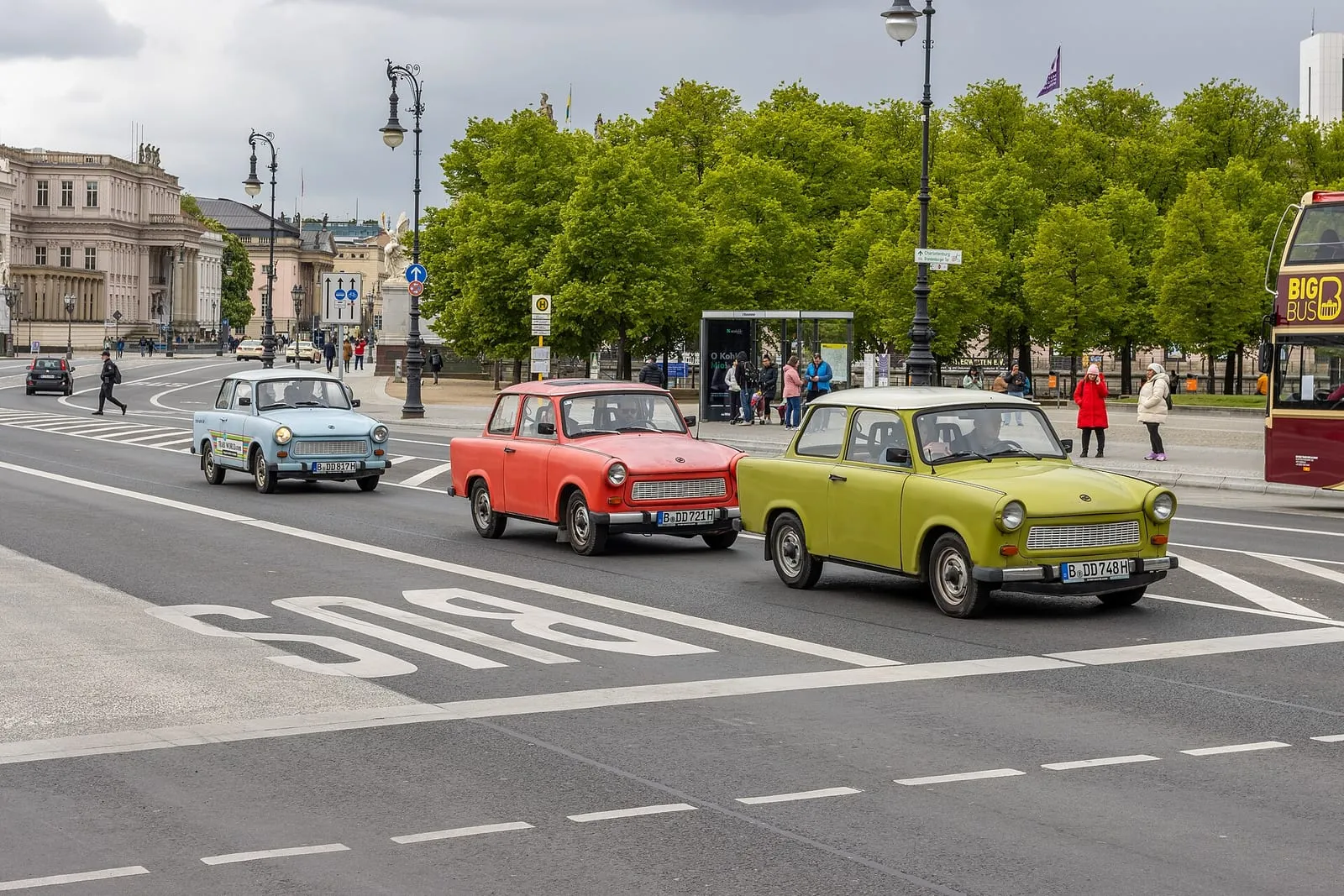 Trois Trabant 601 colorées roulant en convoi devant le Bode-Museum, sur l'île aux musées à Berlin