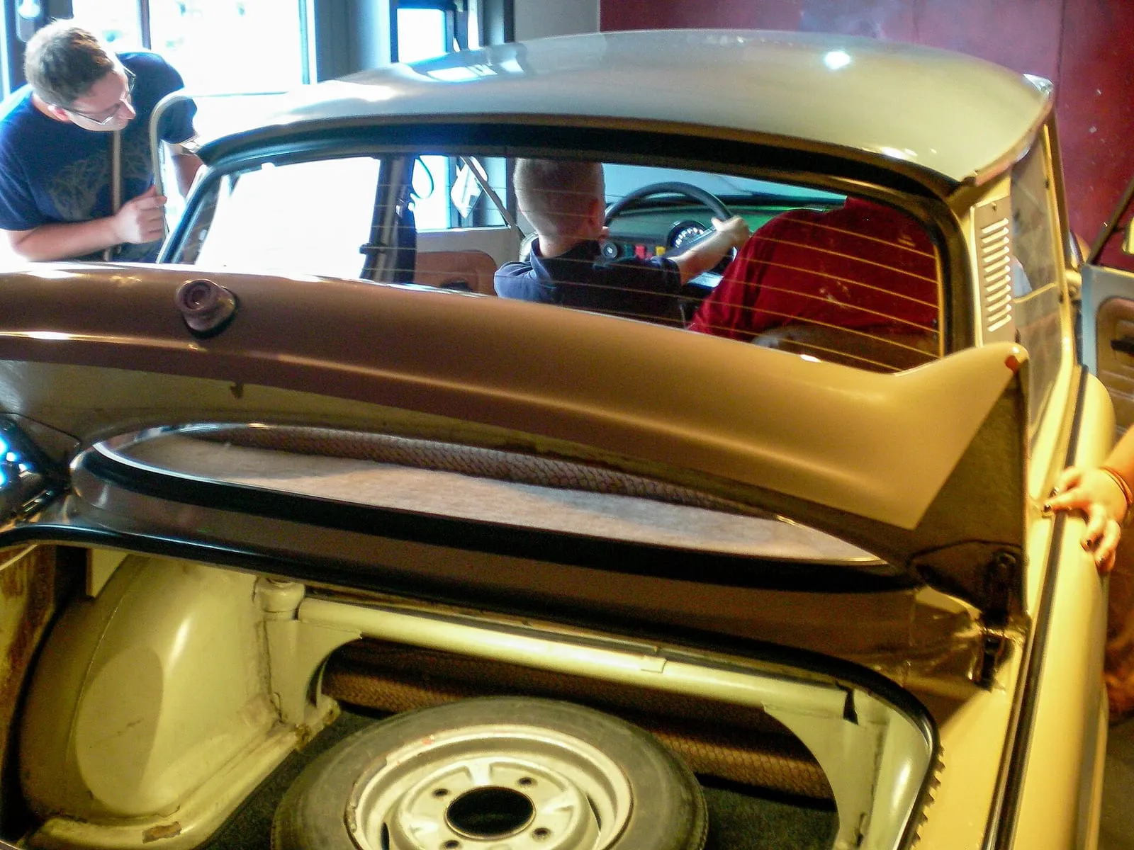 Une Trabant 601 exposée au DDR Museum de Berlin, un visiteur installé au volant face à l'écran du simulateur