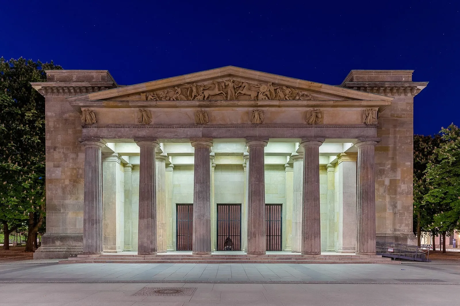 La Neue Wache de Schinkel illuminée de nuit, sa colonnade dorique et, à l'intérieur, la Pietà de Käthe Kollwitz