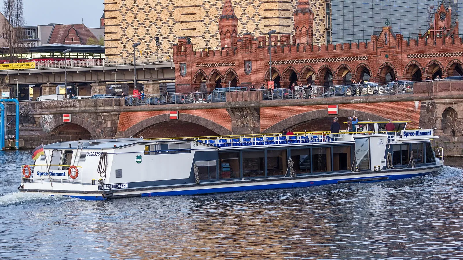 Un bateau de croisière touristique de la Spree, le Spree-Diamant, passant devant les tours de briques de l'Oberbaumbrücke